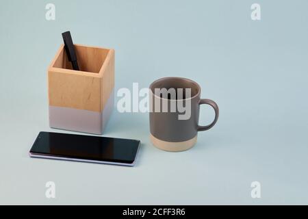 Tasse à café sur fond bleu pâle monochromatique. Grand espace de copie avec bannière avec fournitures de bureau et tasse à café pour les entreprises Banque D'Images