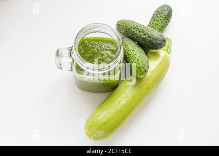 smoothie vert cru dans une tasse de verre et légumes verts. Concombres et courgettes Banque D'Images