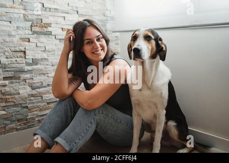 Femme avec un chien assis sur le sol Banque D'Images