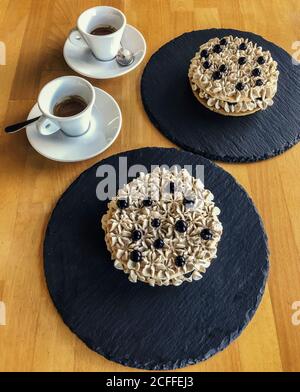 deux paniers à sablés avec crème et bleuets et un couple de tasses de café Banque D'Images