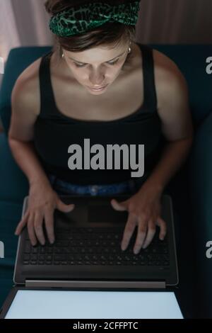 Vue de dessus d'une femme travaillant de la maison avec son ordinateur portable Banque D'Images