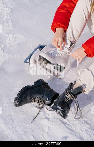 Femme assise sur la neige et changeant de bottes Banque D'Images