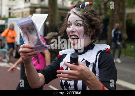 Londres, Royaume-Uni. 3 septembre 2020. Un clown holding de billets de banque rejoint d'autres activistes climatiques de la rébellion de l'extinction qui assistaient à une manifestation du « Carnaval de la corruption » contre la facilitation et le financement par le gouvernement de l'industrie des combustibles fossiles. Les militants de la rébellion contre l'extinction assistent à une série de manifestations de la rébellion de septembre autour du Royaume-Uni pour appeler les politiciens à soutenir le projet de loi sur l'urgence climatique et écologique (projet de loi CEE) qui exige, entre autres mesures, Un plan sérieux pour faire face à la part des émissions du Royaume-Uni et pour stopper les hausses critiques des températures mondiales et pour que les gens ordinaires soient moi Banque D'Images