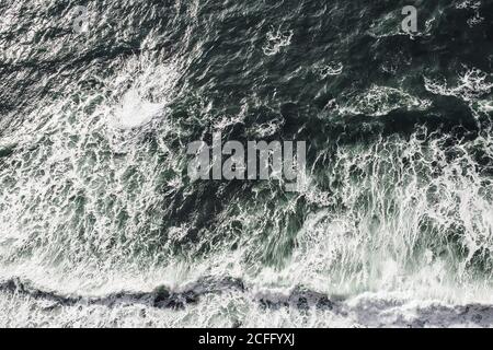 De dessus de l'écrasement de puissantes vagues de l'océan sombre avec Mousse blanche en Irlande Banque D'Images