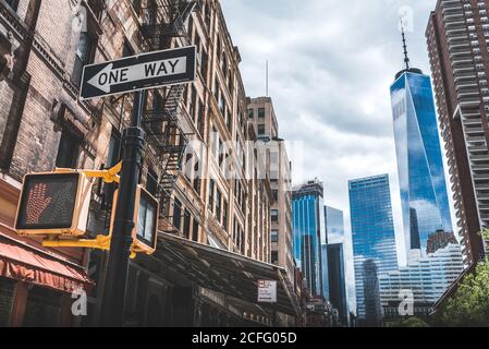 Faible angle de gratte-ciel contemporain avec façades en verre et circulation Prenez la direction de Manhattan Banque D'Images