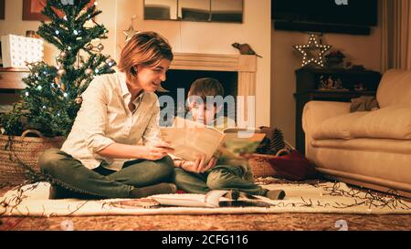 Mère lisant le livre avec son fils la veille de Noël Banque D'Images