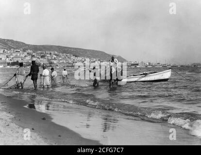 Légende originale: Carmel et Haifa. Pêche transportant dans un filet de traînée. Baie d'Haïfa et Carmel - lieu : Israël--Haïfa ca. 1920 Banque D'Images