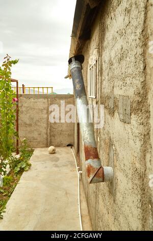 Tuyau d'échappement en acier inoxydable d'une ancienne maison dans les hauts plateaux de l'Asie. Banque D'Images