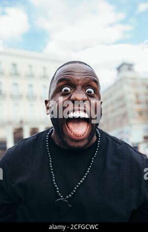 Portrait de noir gai dans les paysages urbains qui dépassent la langue et regarder l'appareil photo Banque D'Images