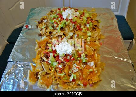 Table de cuisine Nacho table enveloppée de papier aluminium et couverte avec nachos Banque D'Images