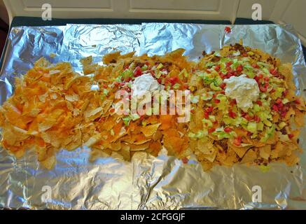 Table de cuisine Nacho table enveloppée de papier aluminium et couverte avec nachos Banque D'Images