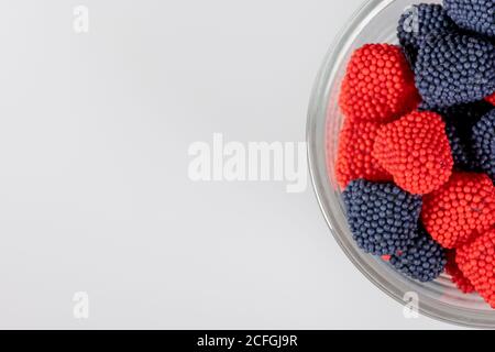 Bord du bol en verre avec bonbons rouges et bleus Banque D'Images