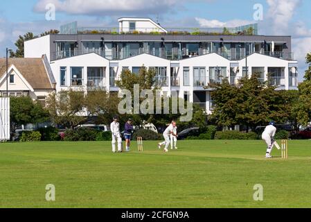 Le cricket se joue à Chalkwell Park, Westcliff on Sea, Southend, Essex, Royaume-Uni. Appartements, appartements donnant sur le parc, London Road. Bowling Bowler Banque D'Images
