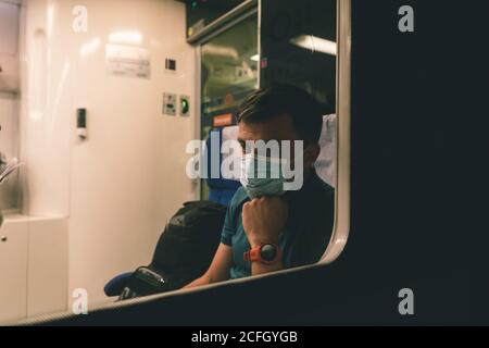 L'homme Sad porte un masque de protection dans le train pour protéger le système respiratoire de l'infection à coronavirus, Covid-19. Mesure préventive. Nouvelle normale. Déplacement Banque D'Images