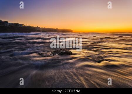 Lever de soleil orange chaud au-dessus de l'horizon de l'océan Pacifique à Bronte Beach, dans la banlieue est de Sydney. Banque D'Images