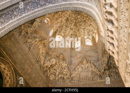 Sculpture au plafond et arche à Alahambra: Décoration détaillée au plafond en plâtre encadrée par une arche très ornée dans une salle en dôme exquise Banque D'Images