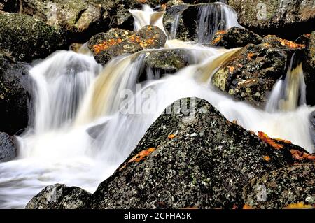 Ruisseau à écoulement rapide plongeant sur un lit robuste d'immenses bornes en granit, Harvard Brook, White Mountain Natinla Forest, New Hampshire. Banque D'Images