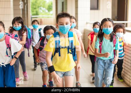 Groupe d'enfants portant un masque facial à l'école après quarantaine covid-19 Banque D'Images