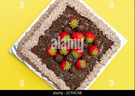 Gâteau au chocolat maison recouvert de saupoudriers au chocolat et de fraises fraîches. Connu au Brésil sous le nom de « Bolo de Brigadeiro ». Banque D'Images