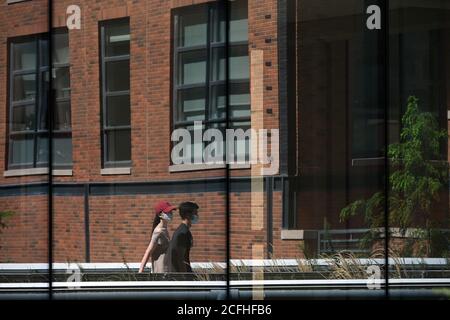 New York, États-Unis. Le 05septembre 2020. Dans les fenêtres voisines, deux personnes portant un masque se promène le long du High Line Park, dans la section récemment ouverte, New York, NY, le 5 septembre 2020. Le High Line Park a étendu l'accès au parc à la 30e rue après avoir récemment rouvert aux visiteurs avec plusieurs restrictions, y compris en s'inscrivant pour une fenêtre de temps espacée de 15 minutes, l'entrée seulement par la rue Gansevoort, en voyageant seulement sur un chemin à sens unique avec des marqueurs sociaux de distance et en sortant à la 23e rue. (Anthony Behar/Sipa USA) crédit: SIPA USA/Alay Live News Banque D'Images