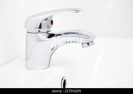 robinet d'eau chromé sur la salle de bains blanche Banque D'Images