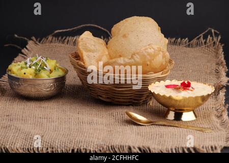 Puri/Bhaji et kheer - recette indienne semi-sèche de pommes de terre épicée également connue sous le nom de Batata ou Aloo ki Sabji, servie avec du poori frit et du khir Banque D'Images