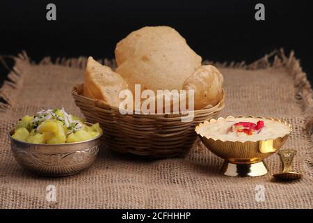 Puri/Bhaji et kheer - recette indienne semi-sèche de pommes de terre épicée également connue sous le nom de Batata ou Aloo ki Sabji, servie avec du poori frit et du khir Banque D'Images