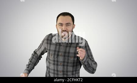Beau homme marchant, chantant et dansant à la musique sur fond de gradient. Banque D'Images