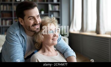 Gros plan jeune homme rêveur et femme mûre embrassant Banque D'Images