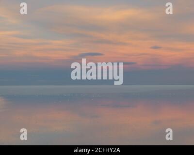Doux nuageux. Lever de soleil doux sur le lac salé. Nuages reflétés sur les flats de sel d'Uyuni en Bolivie. Ciel de couleur tendre. Magnifique paysage le matin. Banque D'Images