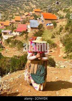 Vieille signora de Isla del sol, Bolivie. Bolivienne Aymara femme en vêtements traditionnels avec aguayo monte sur la colline. Cholita autochtone de Bolivie Banque D'Images