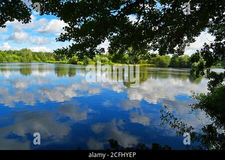 Ciel bleu réfléchissant sur l'eau à Lackford Lakes, réserve naturelle, Suffolk, Royaume-Uni Banque D'Images