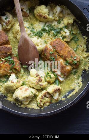 Chou-fleur au curry avec merlu dans une poêle Banque D'Images