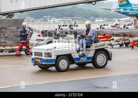 Fukuoka, Japon - 14 juillet 2019 - un préposé à la manutention des bagages conduit un arrache-bagages à l'aéroport de Fukuoka, au Japon, le 14 juillet 2019 Banque D'Images