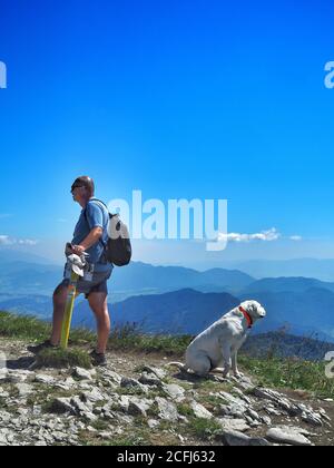 LITTLE FATRA, SLOVAQUIE - 08/03/2018: Homme caucasien prenant le repos avec son chien blanc pendant la randonnée dans le parc national de Little Fatra. Banque D'Images