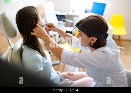 Femme médecin et patient au bureau, examen de l'oreille Banque D'Images