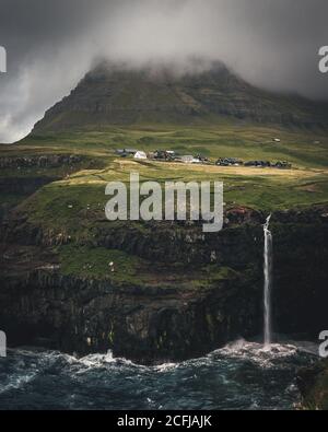 Vue aérienne du village de Gasadalur et de Mulafossur sa cascade emblématique, Vagar, îles Féroé, Danemark. Vue brute dans l'océan Atlantique nord Banque D'Images