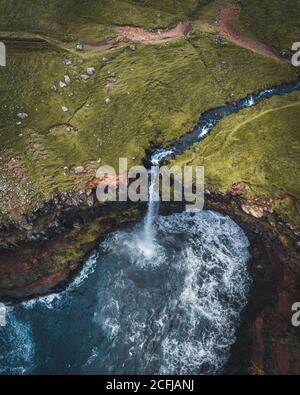 Panorama aérien par drone de la cascade de Mulafossur, Vagar, îles Féroé, Danemark. Vue brute dans l'océan Atlantique nord. Végétation luxuriante en été. Banque D'Images