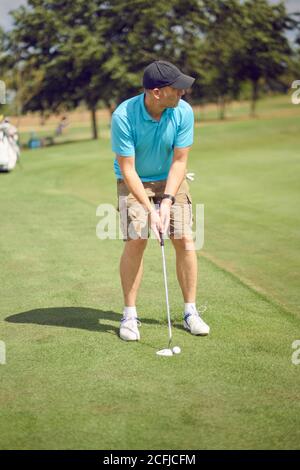 Le golfeur se prépare à jouer un coup sur la doublure du fairway lui-même avec le trou avant de prendre son swing dedans un concept de style de vie sportif et actif Banque D'Images