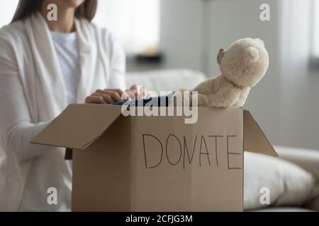 Un bénévole gentil met des choses pour les familles pauvres dans un ensemble de charité. Banque D'Images