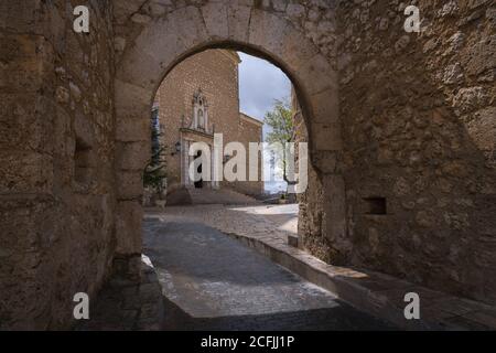 Vue de la façade principale de l'église notre-Dame de l'Assomption par le portique d'entrée de l'enceinte de l'église à Tarancón, Cuenca, Espagne Banque D'Images