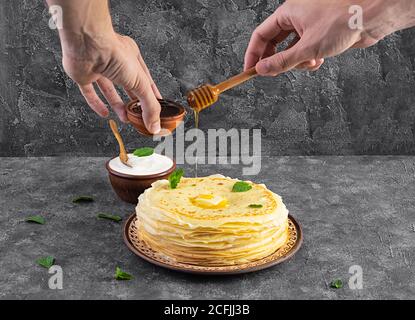 Délicieuses crêpes au miel et à la crème sure sur fond de bois Banque D'Images