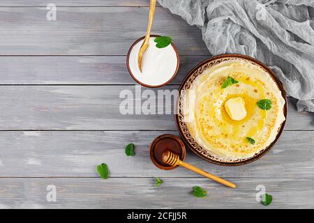 Délicieuses crêpes au miel et à la crème sure sur fond de bois Banque D'Images