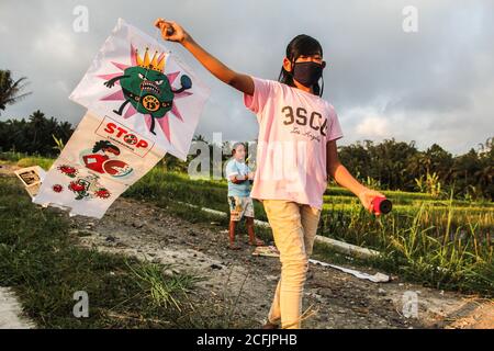 Sleman, YOGYAKARTA, INDONÉSIE. 6 septembre 2020. Un enfant portant un masque joue avec un cerf-volant avec une invitation à prévenir la propagation du virus corona à Sleman, Yogakarta, Indonésie, le dimanche 6 septembre 2020. Le gouvernement a informé que 3,444 nouveaux cas du patient ont été confirmés positifs pour le virus corona. Ainsi, il y a, à ce jour, 194,109 cas positifs de Covid-19 en Indonésie. Credit: Slamet Riyadi/ZUMA Wire/Alamy Live News Banque D'Images