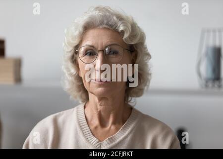 Portrait de tête confiante femme mature portant des lunettes à la maison Banque D'Images