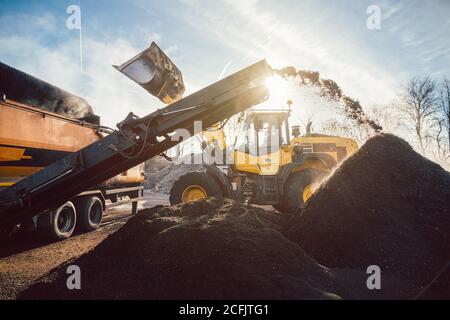 Des machines lourdes déplacent la terre et la biomasse dans les travaux de compost Banque D'Images