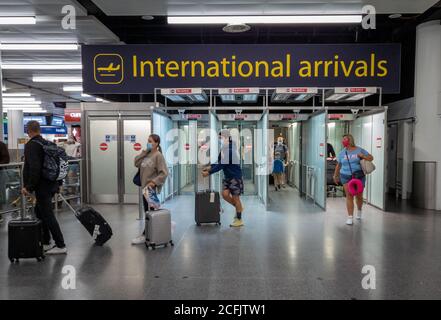 Passagers aériens sortant des portes d'embarquement internationales du terminal nord de l'aéroport de Gatwick. Banque D'Images