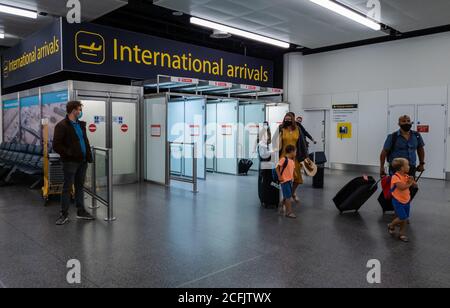 Passagers aériens sortant des portes d'embarquement internationales du terminal nord de l'aéroport de Gatwick. Banque D'Images