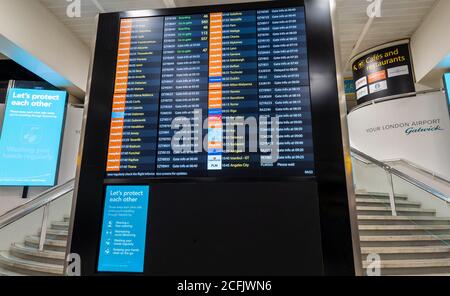 Le tableau d'affichage des informations de vol dans le salon de départ du terminal nord de l'aéroport de Gatwick. Banque D'Images