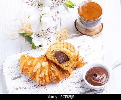 Délicieux croissant frais, amandes en tranches, avec garniture au chocolat, coupé, gros plan Banque D'Images